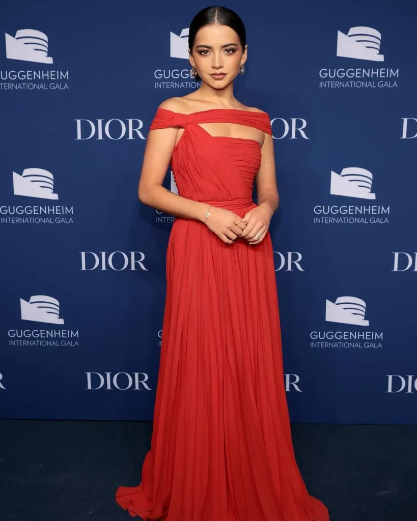 Isabela Moner standing in a podium wearing red gown