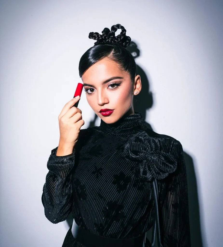 Isabella Moner posing wearing red lipstick and black gown